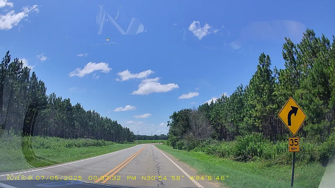 Yellow Curve warning sign with a 35 MPH advisory speed plaque beside a rural two-lane highway in Grady County, Georgia