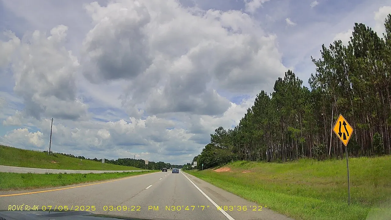 Yellow Divided Highway Ends warning sign beside eastbound US 84, with the grass median and the westbound lanes on the left, Brooks County, Georgia