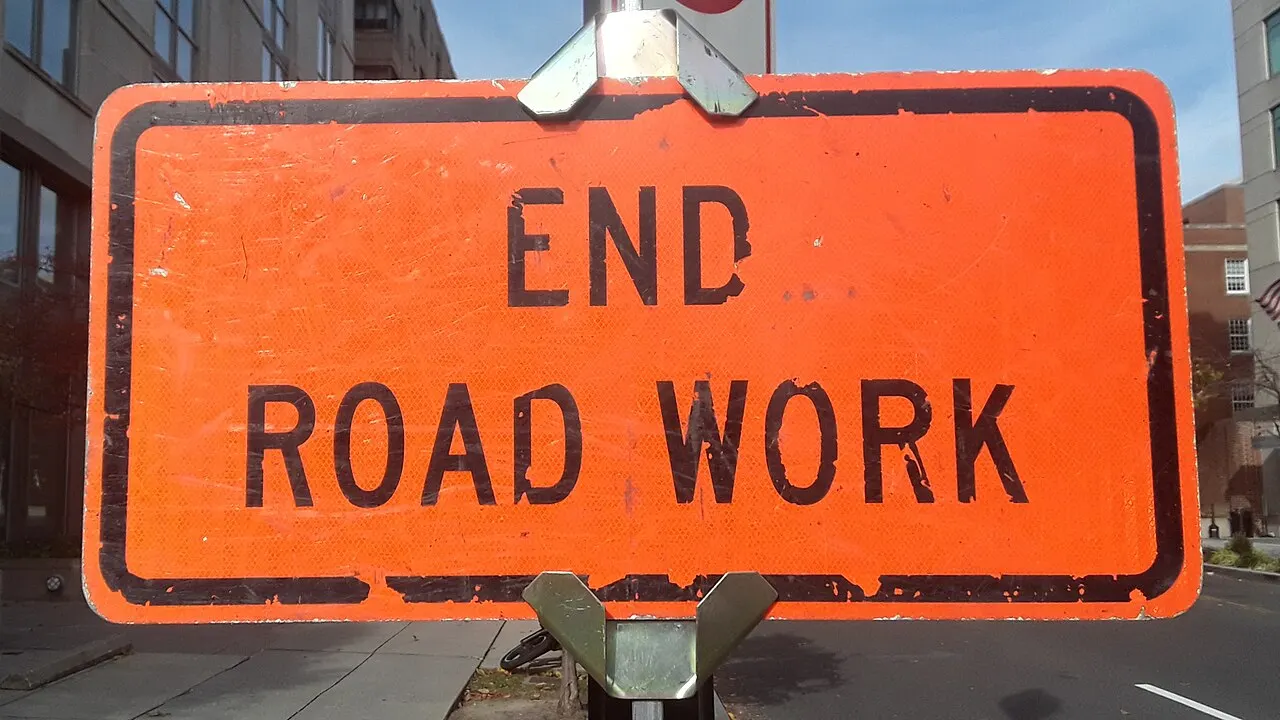 Orange rectangular END ROAD WORK sign on a portable stand on a city street in Washington, DC