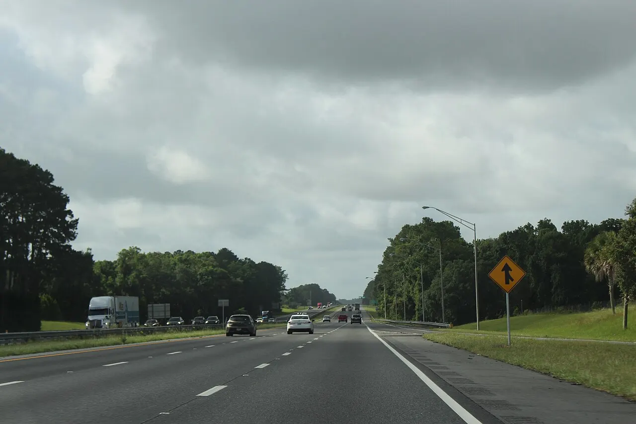 Yellow Merge warning sign on the right shoulder of southbound Interstate 75 in Columbia County, Florida
