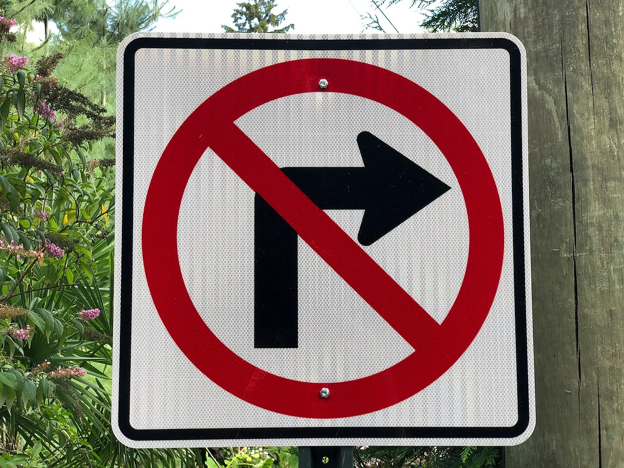No Right Turn sign, a black right arrow inside a red circle and slash on a white square