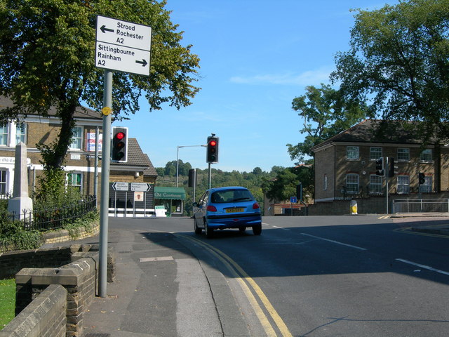 A UK road junction with direction signs and traffic lights, the most-cited fault category in the DVSA marking sheet