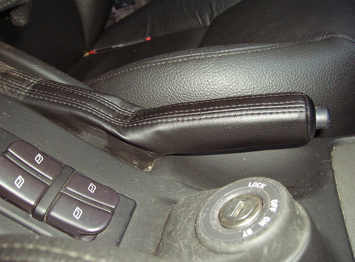 A handbrake lever inside a UK car, used when moving off on hills to prevent rolling back