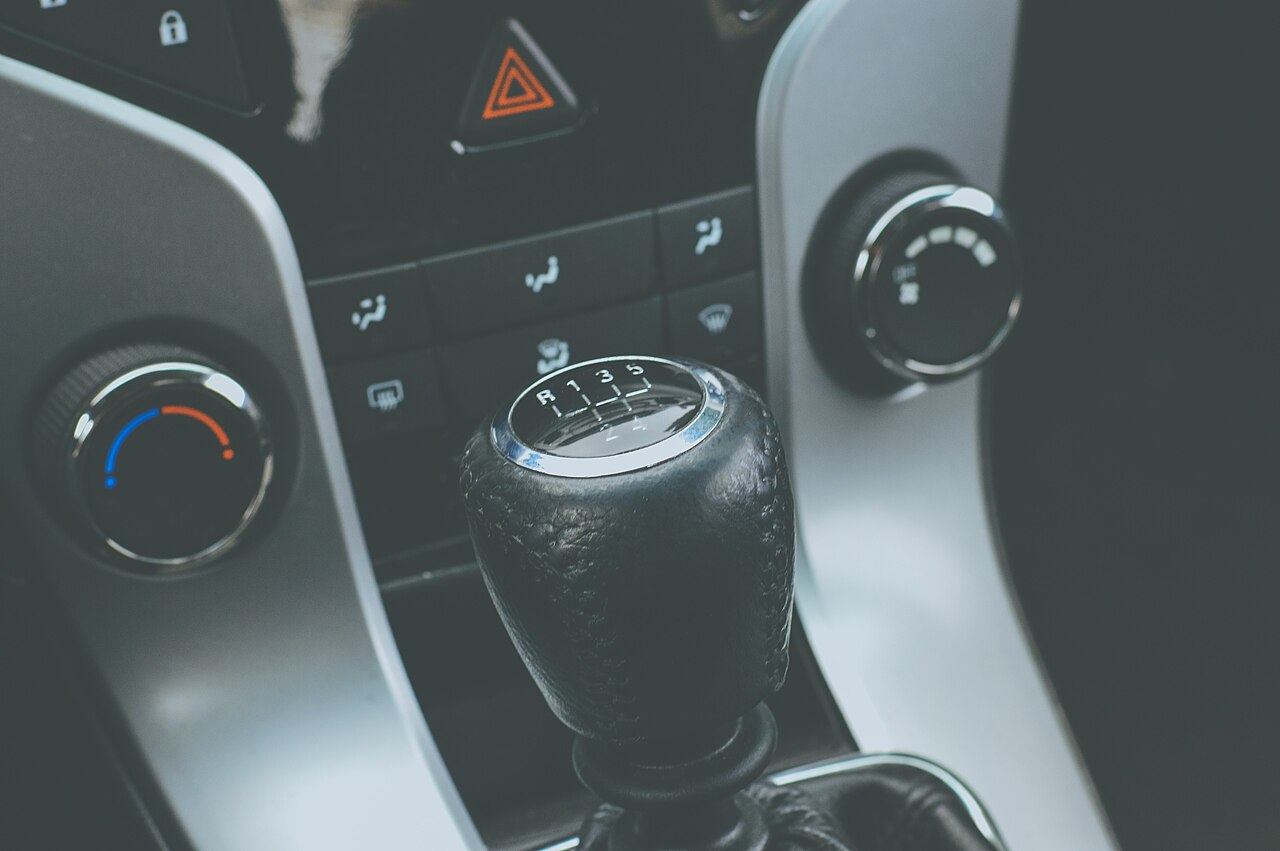 A manual gearbox gear stick, the control paired with the handbrake on a hill start