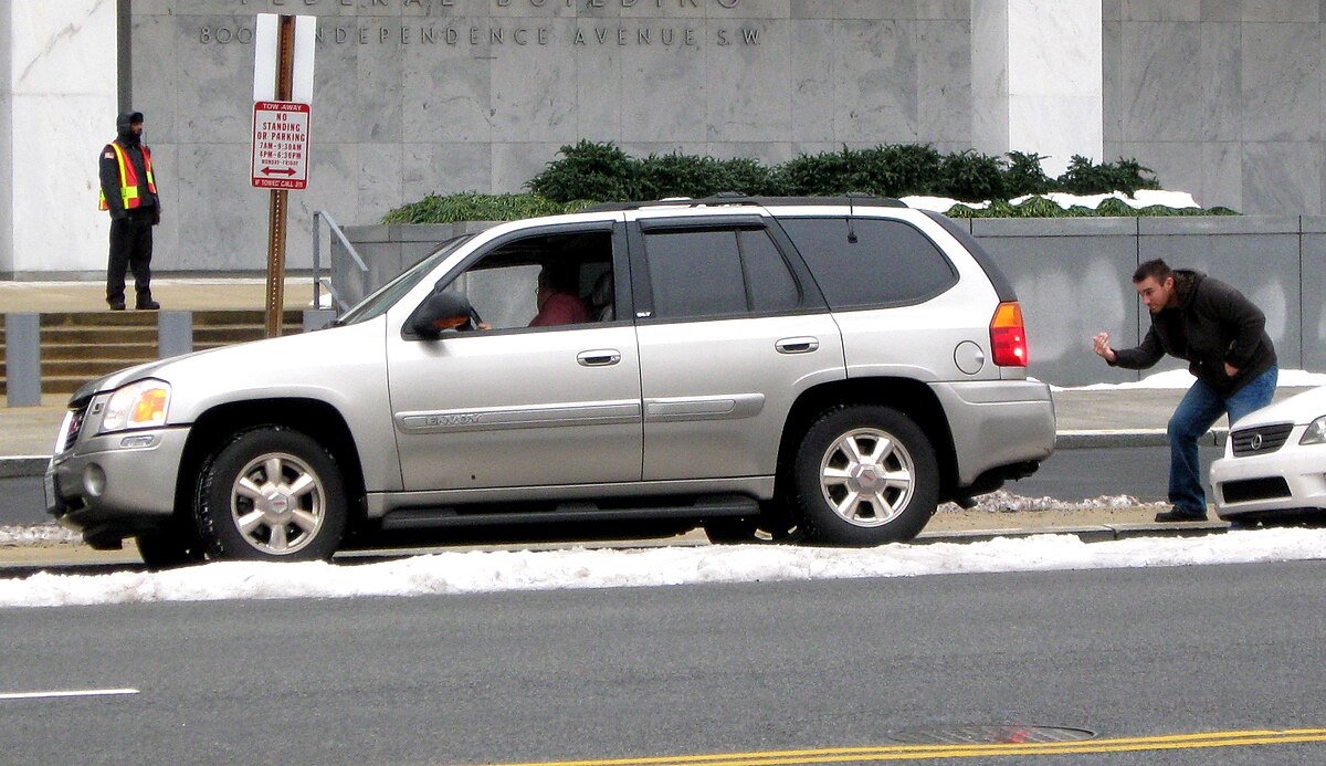 Parallel parking demonstrated between two cars