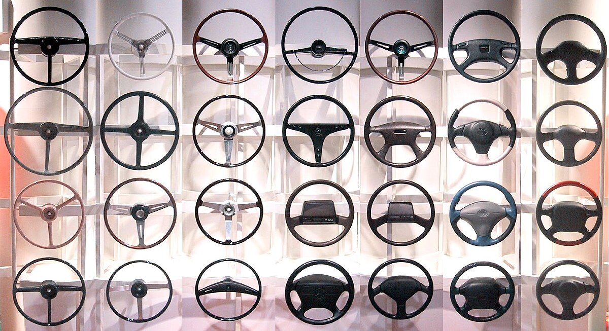 Steering wheels from different periods, evoking the long road from first lesson to test-ready