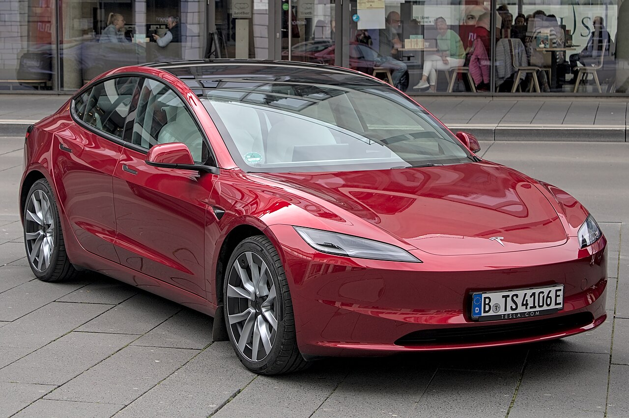 Tesla Model 3 electric vehicle on a UK road -- electric cars have no clutch and are classified as automatic for DVSA test purposes