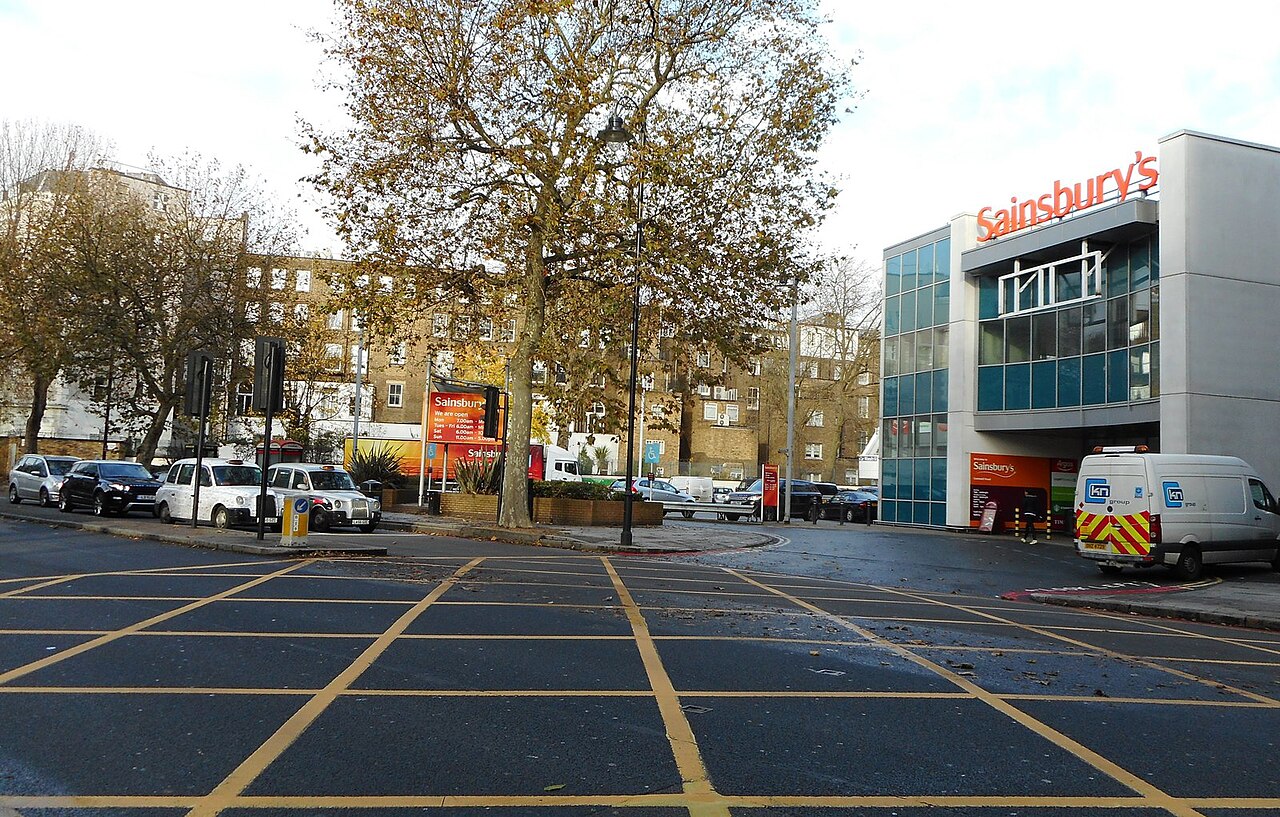 A yellow box junction at a busy UK urban crossroads, typical of the inner-Birmingham route fixtures