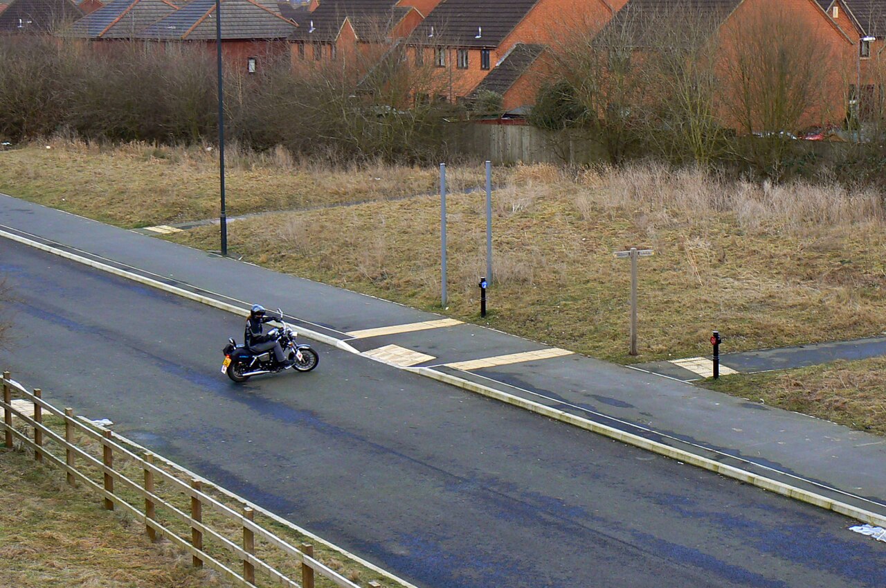 A motorcyclist riding through a UK housing estate
